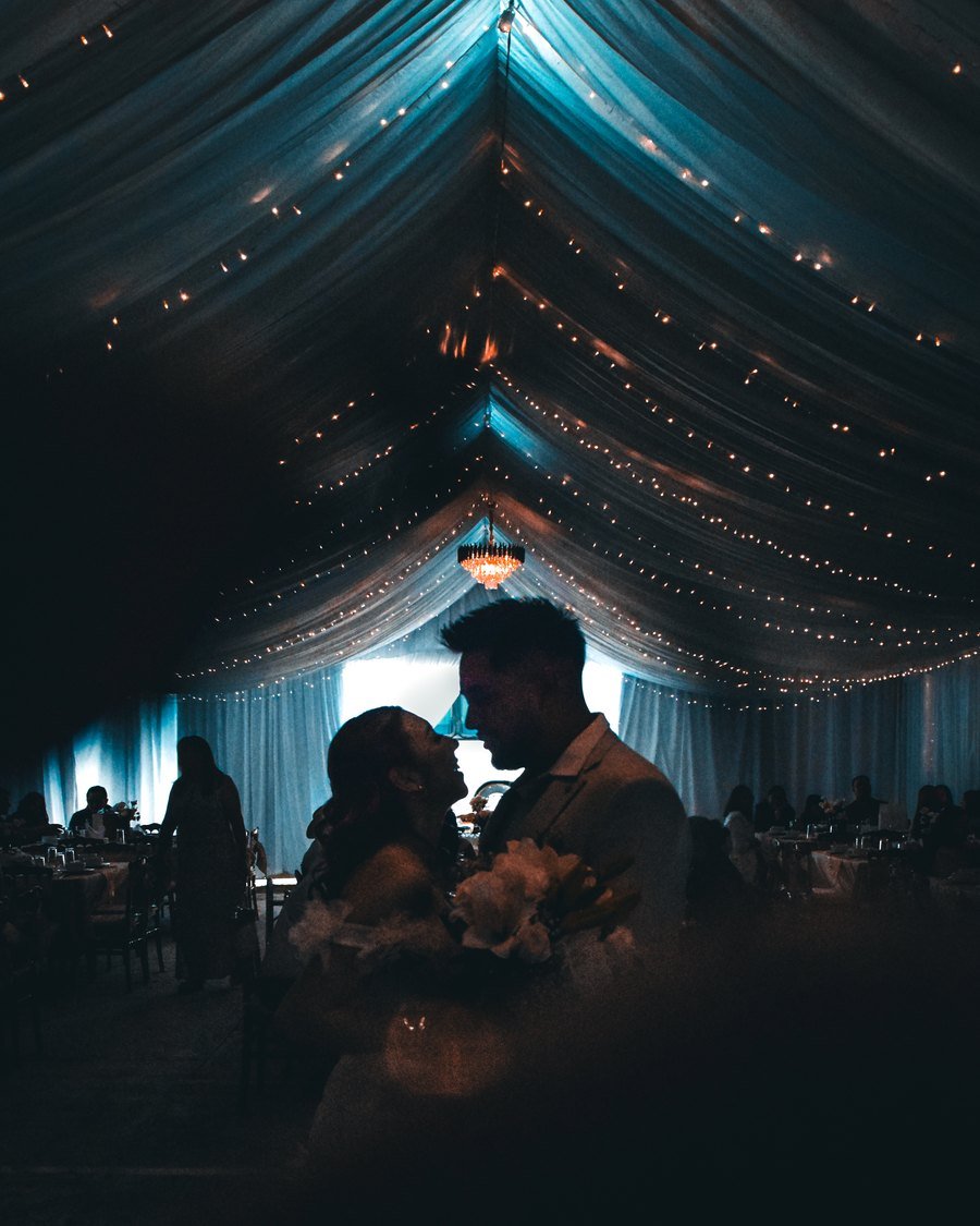 Novios en la carpa iluminada durante una boda en el Estado de México